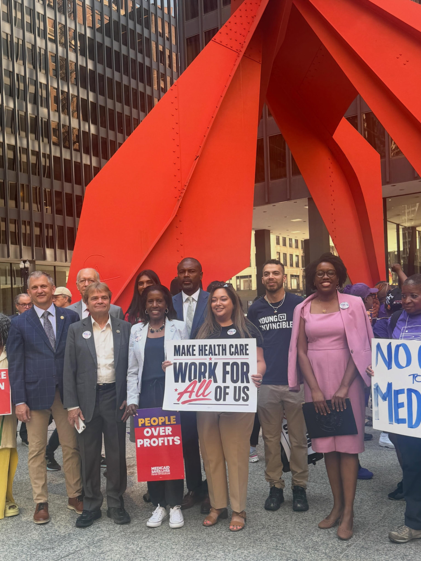 Members of Congress and advocates gathered under the Flamingo sculpture in Chicago holding campaign signs